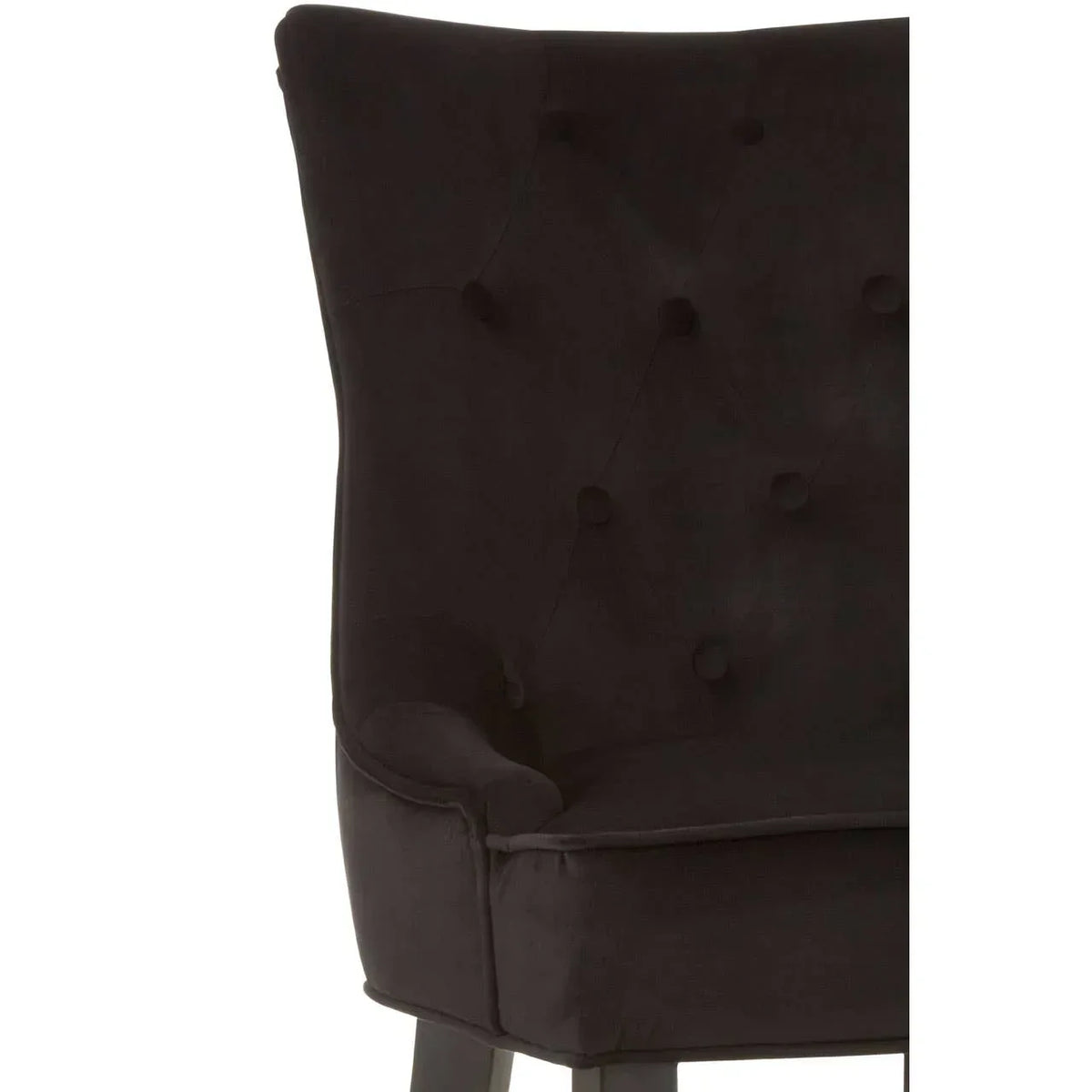 Close-up of black velvet dining chair with tufted backrest and dark wood legs