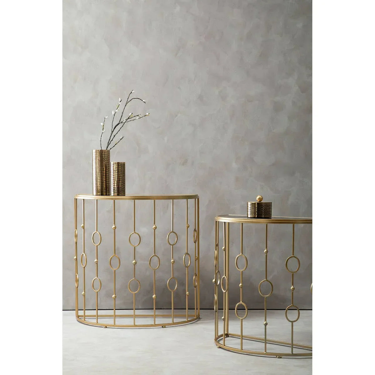 Gold metal console tables with circular geometric frame and decorative vases on top