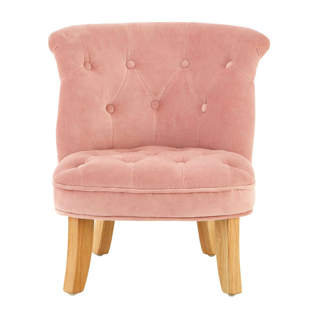 A small, pink velvet chair designed for kids, featuring a curved backrest with button tufting and four wooden legs in a light finish
