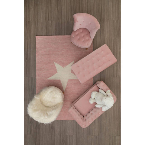 A cozy kids' white faux fur chair placed on a soft pink rug featuring a star design, surrounded by a pink storage box and a fluffy white pouf, all set against a wooden floor