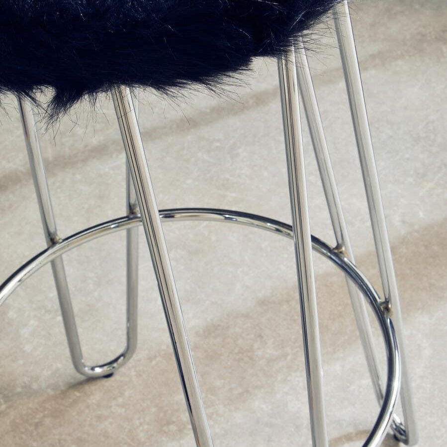 Bar stool with black faux fur seat and chrome metal legs on tiled floor