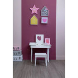 White children's dressing table with stool against pink wall, decorated with wall art and storage boxes
