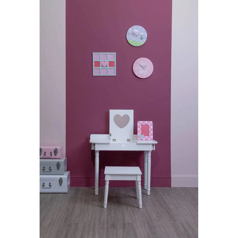 White dressing table and stool with heart mirror beside pink storage boxes on wood floor