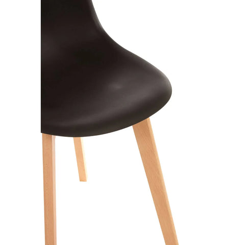 Black dining chair seat with wooden legs, close view of curved seat and angled legs