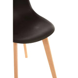Black dining chair seat with wooden legs, close view of curved seat and angled legs