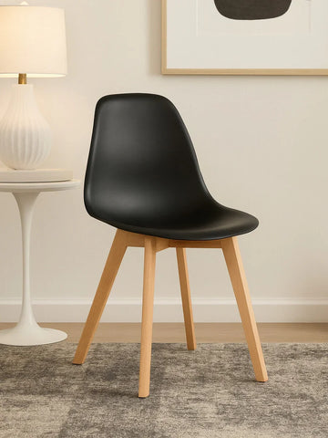 Black dining chair with wooden legs on a grey rug in a modern living room setting