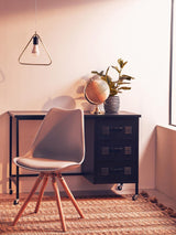Modern desk and chair set with black drawers, globe, plant and pendant light in home office