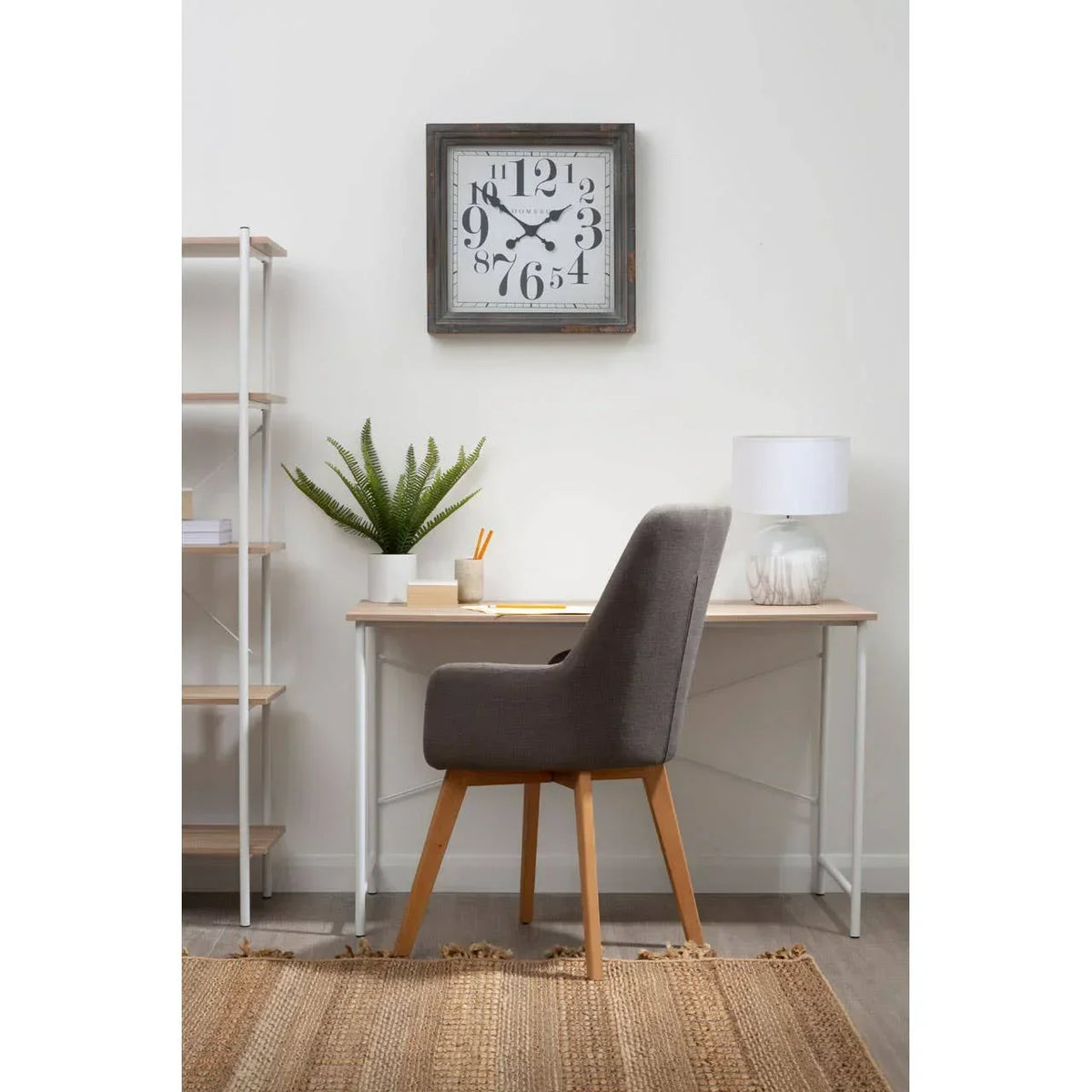 Grey upholstered accent chair at modern office desk with lamp and plant
