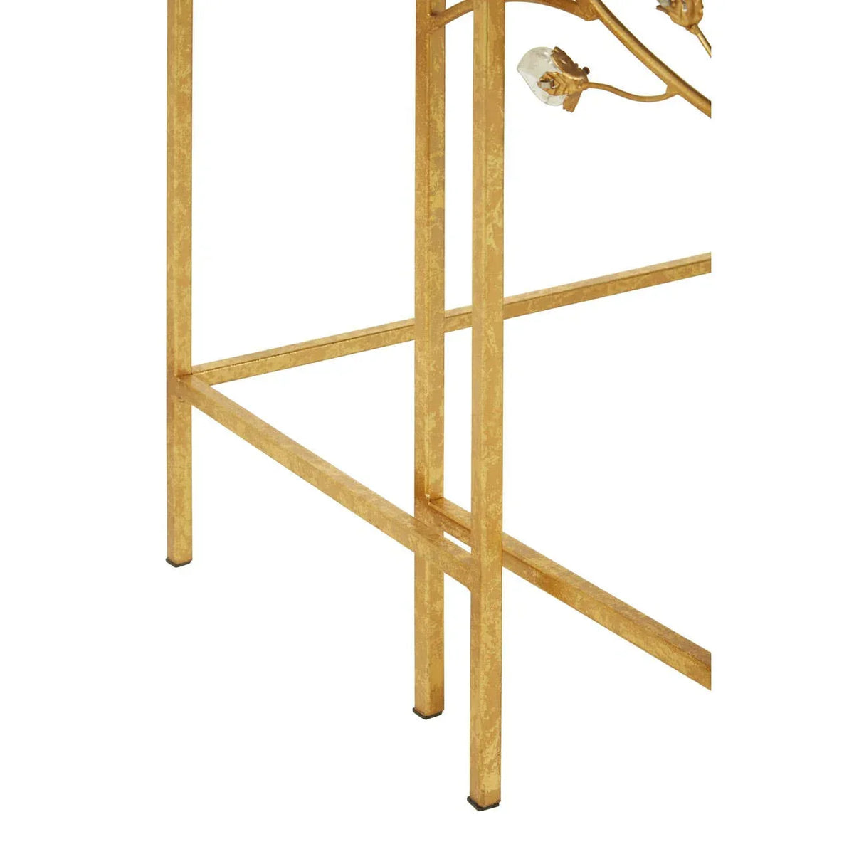 Gold metal furniture leg detail with decorative floral accent and crossbar support