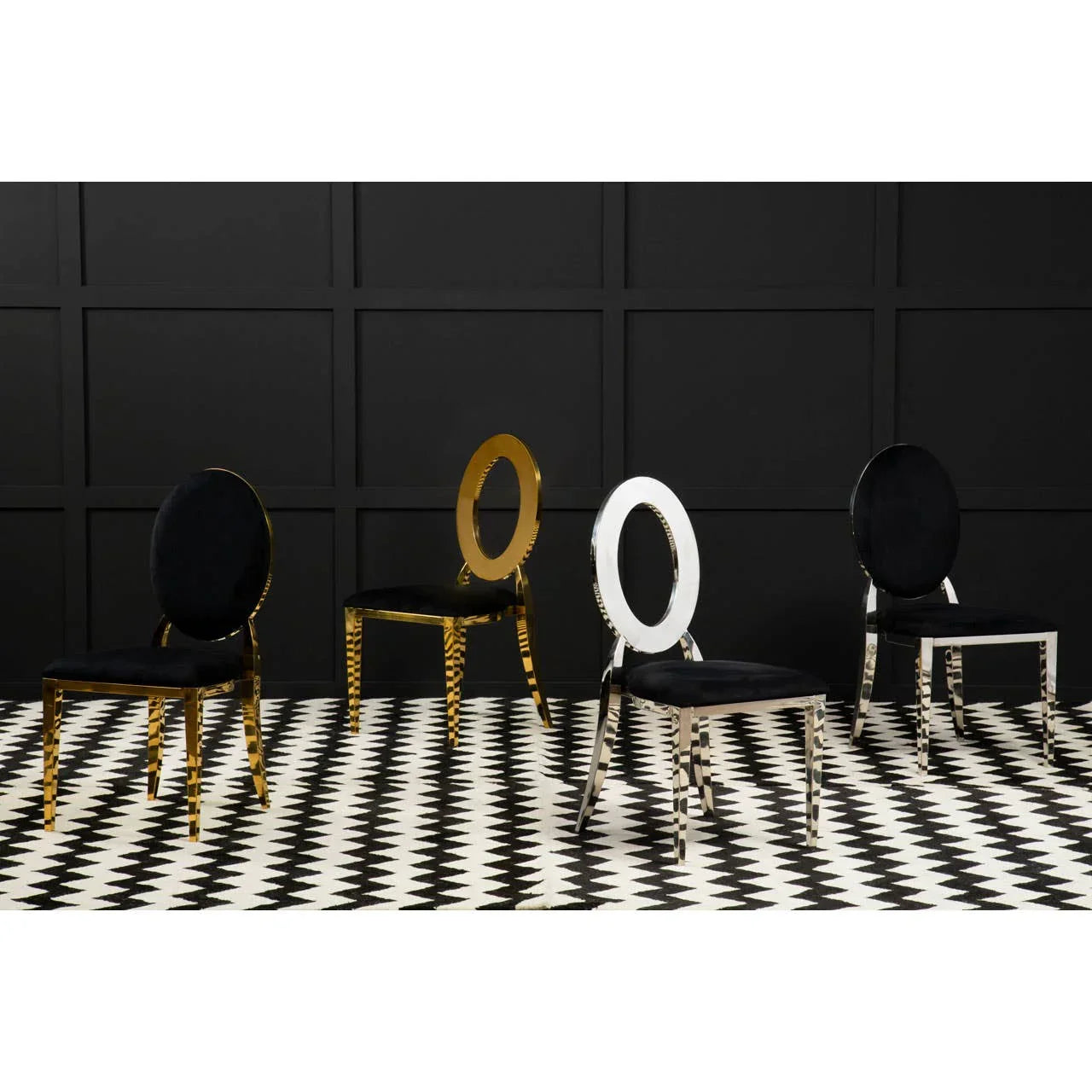 Modern dining chairs with black velvet seats, gold and chrome oval backs, on checkered floor