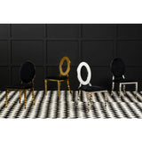Modern dining chairs with black velvet seats, gold and chrome oval backs, on checkered floor