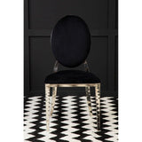 Black velvet dining chair with oval back and chrome legs on patterned rug