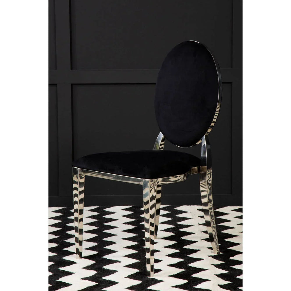 Black velvet dining chair with chrome oval backrest on chevron patterned rug