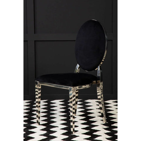 Black velvet dining chair with chrome oval backrest on chevron patterned rug