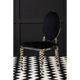 Black velvet dining chair with chrome oval backrest on chevron patterned rug