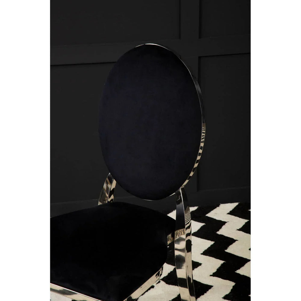Black velvet dining chair with chrome frame on monochrome patterned rug