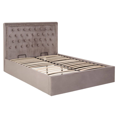 Double ottoman bed upholstered in grey velvet with a tufted headboard and a spacious storage compartment beneath the mattress base. The bed features a modern design with clean lines and a sturdy frame
