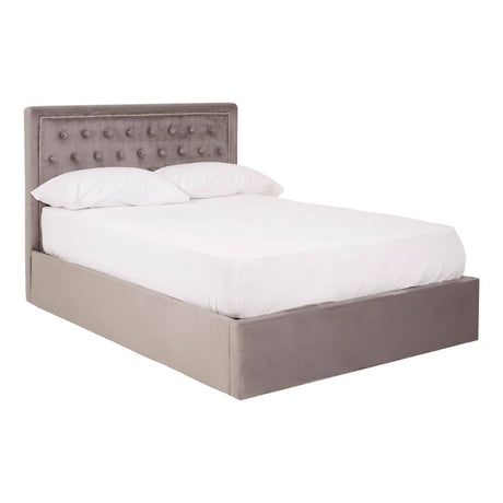 Double bed upholstered in grey velvet with a tufted headboard and a low-profile base, featuring a spacious storage compartment underneath. The bed is dressed with a white mattress and bedding