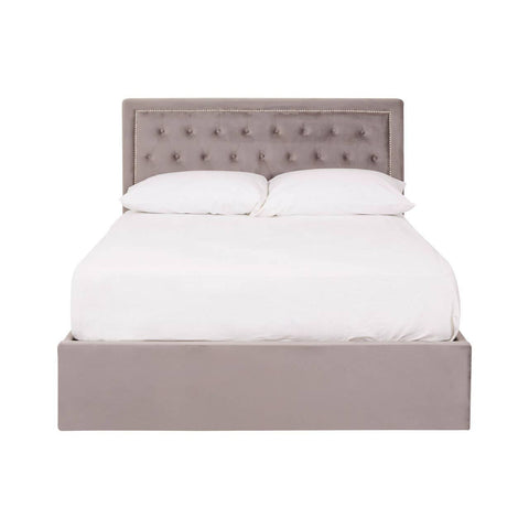 Double bed with a grey velvet upholstered headboard featuring button tufting, complemented by a matching grey velvet base. The bed is styled with a white mattress and bedding, creating a clean and modern look