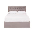 Double bed with a grey velvet upholstered headboard featuring button tufting, complemented by a matching grey velvet base. The bed is styled with a white mattress and bedding, creating a clean and modern look