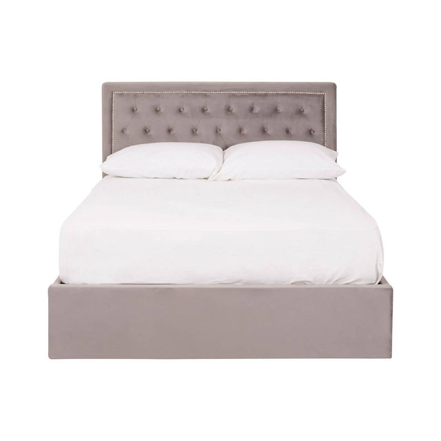 Double bed with a grey velvet upholstered headboard featuring button tufting, complemented by a matching grey velvet base. The bed is styled with a white mattress and bedding, creating a clean and modern look