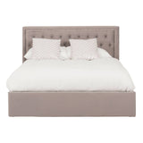 Grey upholstered king bed with a tufted headboard, featuring a plush white comforter and two decorative pillows. The bed has a spacious ottoman base for additional storage