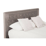 Grey upholstered headboard with button tufting, two white decorative pillows with a subtle pattern, and a white bedspread on a king-sized bed