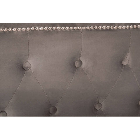 Close-up view of the tufted headboard of the Hannah Grey Ottoman King Bed, featuring a soft grey fabric with decorative buttons and a row of metallic nailhead trim along the top edge