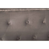 Close-up view of the tufted headboard of the Hannah Grey Ottoman King Bed, featuring a soft grey fabric with decorative buttons and a row of metallic nailhead trim along the top edge