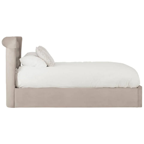 Beige upholstered bed frame with tufted headboard, white bedding and accent pillow side view