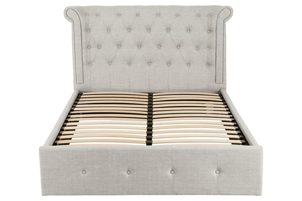 Grey upholstered bed frame with button tufted headboard and wooden slats, front view