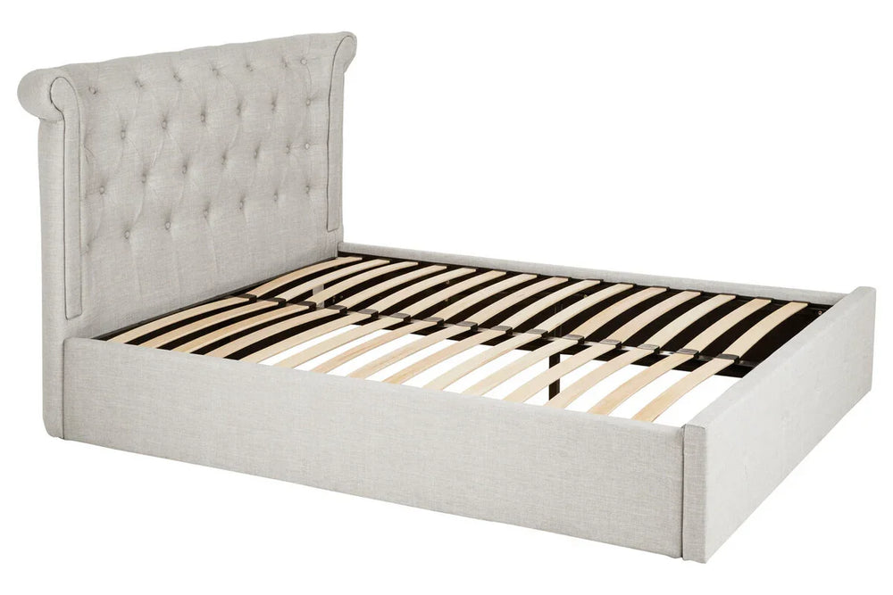 Light grey upholstered bed frame with tufted headboard and wooden slats, angled view