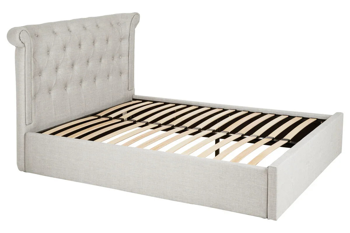 Light grey upholstered bed frame with tufted headboard and wooden slats, angled view
