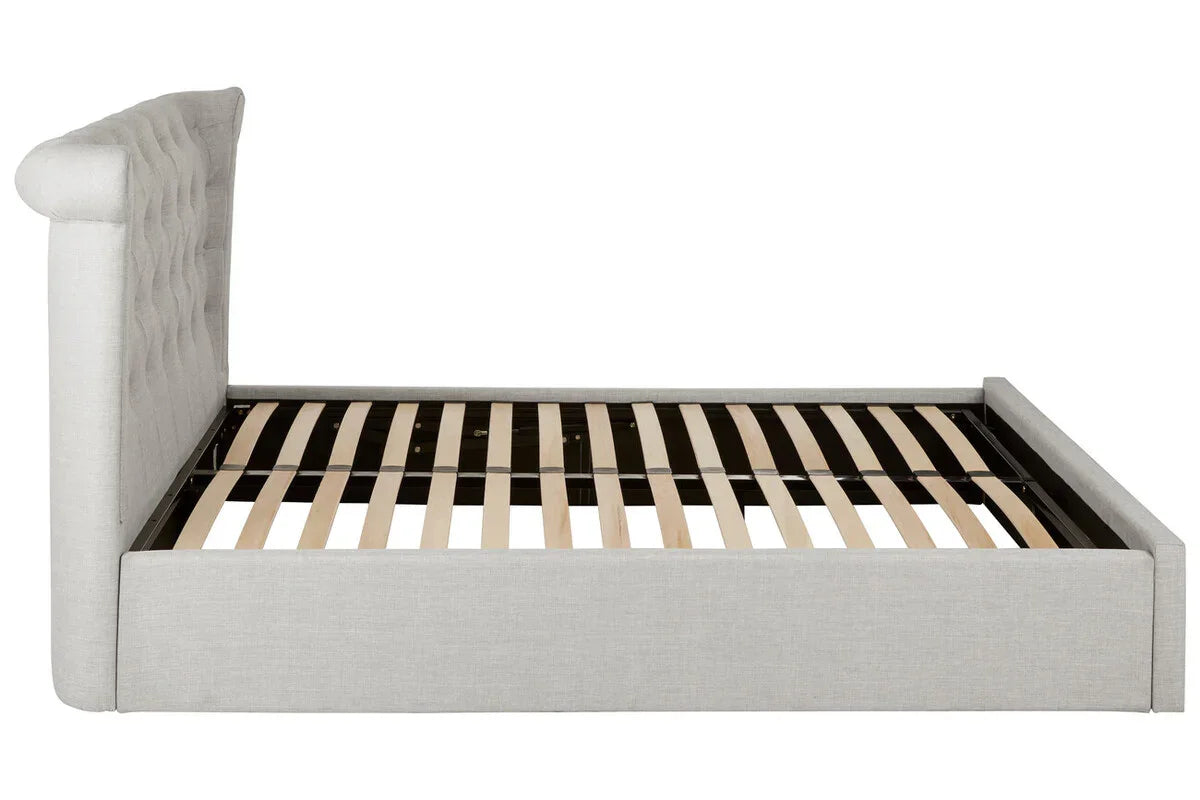Side view of fabric upholstered bed frame with tufted headboard and wooden slats