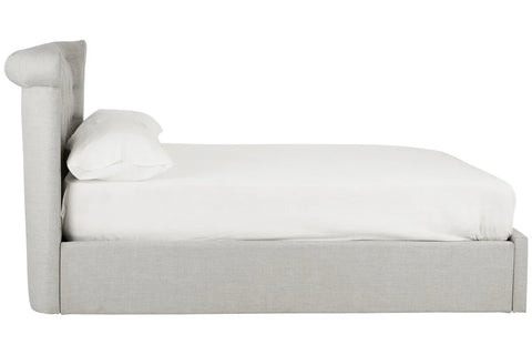 Side view of grey upholstered bed frame with white bedding and pillow