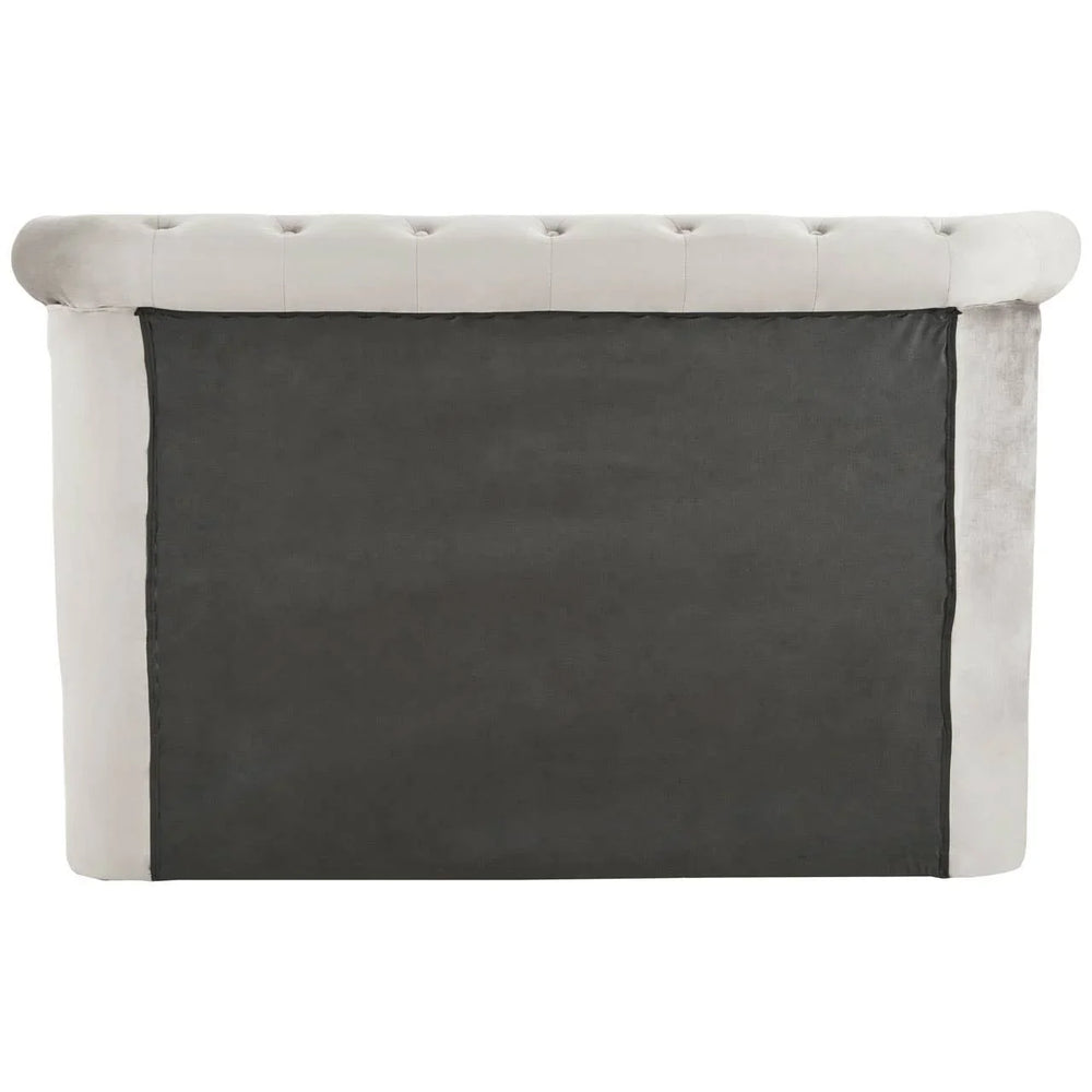 Back view of grey upholstered bed headboard with button-tufted top edge