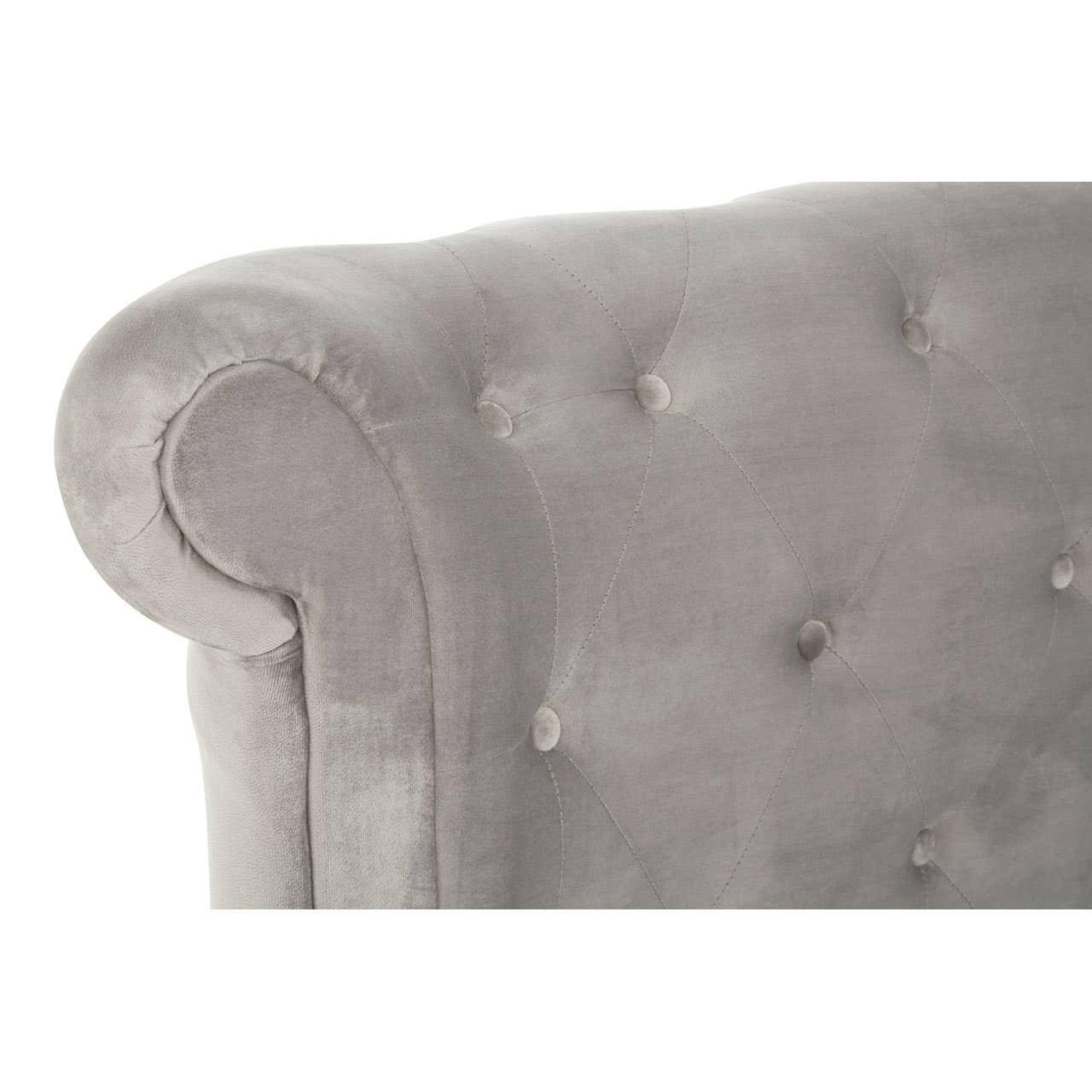 Grey velvet sofa armrest with button-tufted upholstery, close up on rolled detail