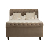 Grey ottoman double bed with a tufted headboard, featuring two cream-colored pillows on top of a mattress, and supported by dark wooden legs. The bed has a storage compartment beneath the mattress