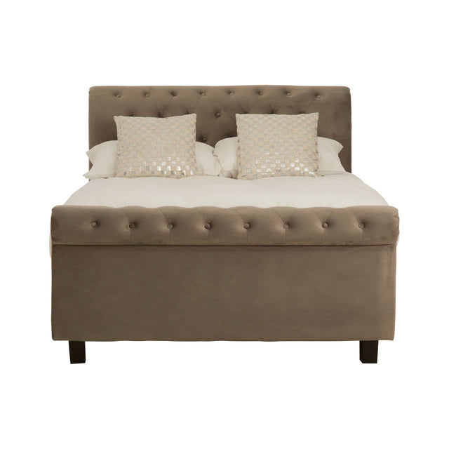 Grey ottoman double bed with a tufted headboard, featuring two cream-colored pillows on top of a mattress, and supported by dark wooden legs. The bed has a storage compartment beneath the mattress