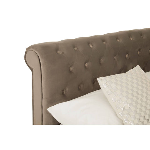 Grey upholstered headboard with tufted detailing and a soft fabric finish, accompanied by a decorative cream-colored pillow resting on the bed