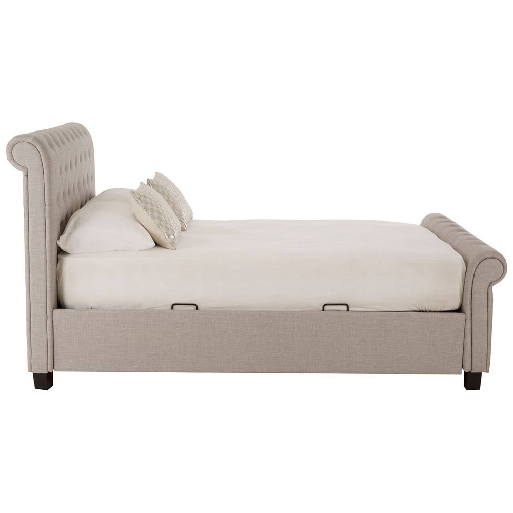 Light grey ottoman double bed with a tufted headboard, featuring a spacious mattress and two decorative cushions. The bed has a sleek design with wooden legs and a storage compartment underneath