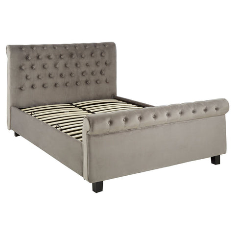 Grey upholstered king bed with a tufted headboard, decorative buttons, and a low-profile footboard. The bed features a sturdy frame with wooden slats for mattress support and black legs
