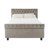 Grey upholstered king bed with a tufted headboard, featuring a padded design and decorative buttons, resting on four black legs. The bed is shown without bedding, highlighting its clean lines and modern aesthetic