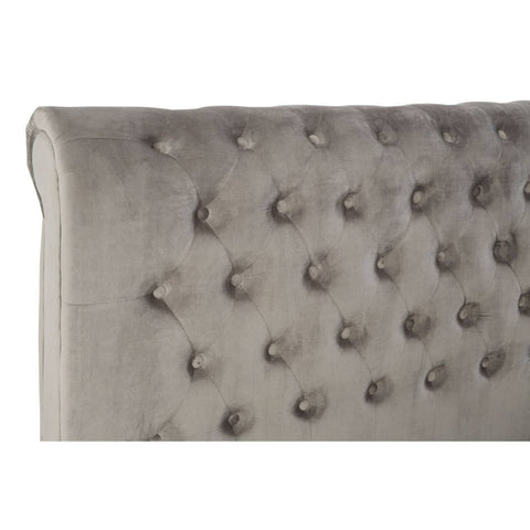 Grey upholstered headboard with tufted detailing and decorative buttons, showcasing a soft fabric texture. The design features a rounded top edge, adding an elegant touch to the overall aesthetic