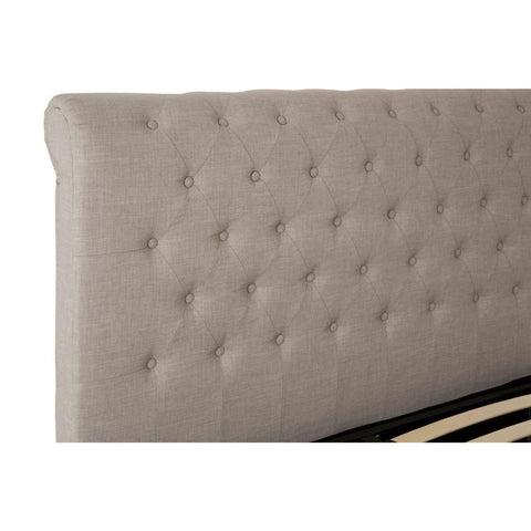 Beige upholstered bed headboard with button-tufted design in close-up view