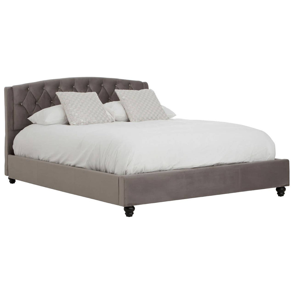 Grey velvet king bed with a tufted headboard, featuring two decorative pillows and a white comforter, resting on dark wooden legs