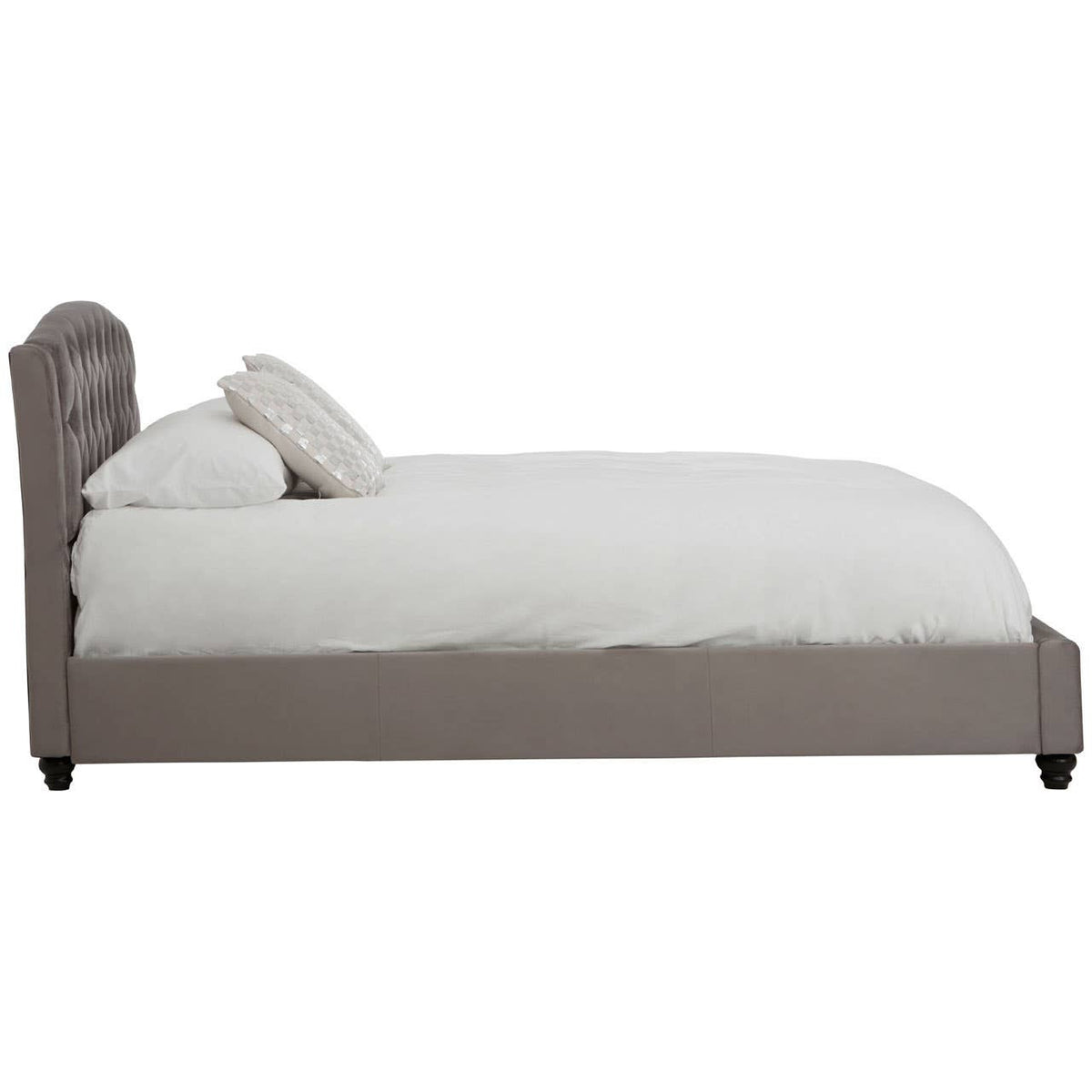 Grey velvet king bed with a tufted headboard, white bedding, and two decorative pillows, set against a plain background