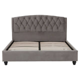 Grey velvet king bed with a tufted headboard and a low-profile frame, featuring storage space underneath. The bed stands on four wooden legs, showcasing a modern and elegant design suitable for a stylish bedroom