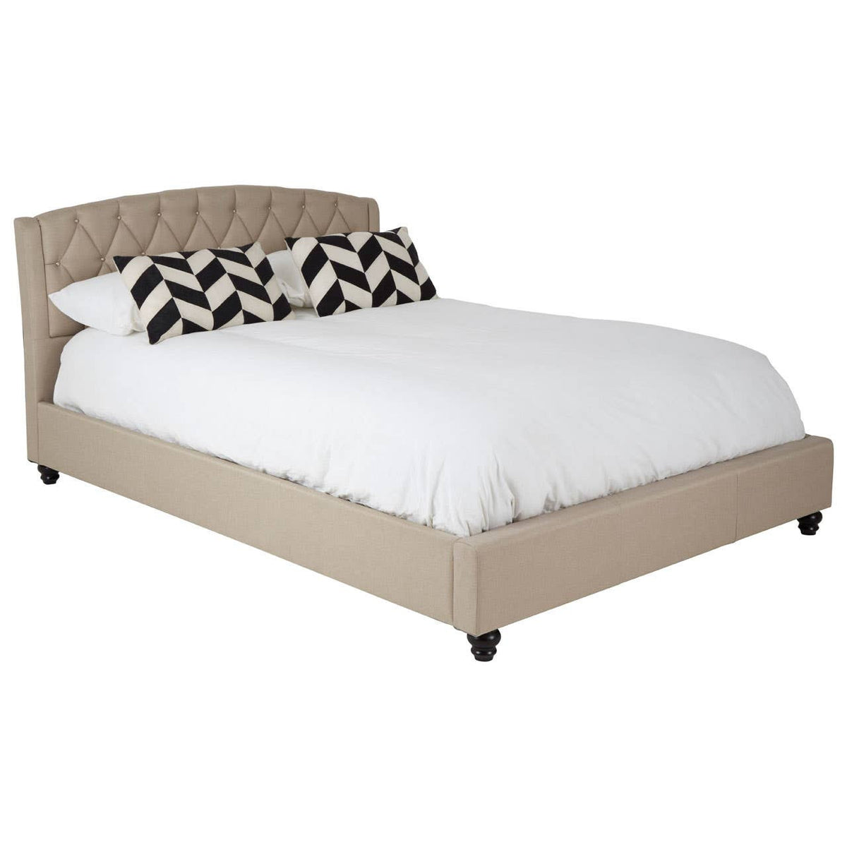 Beige king bed with a tufted headboard, featuring a white bedding set and decorative black and white pillows, resting on dark wooden legs