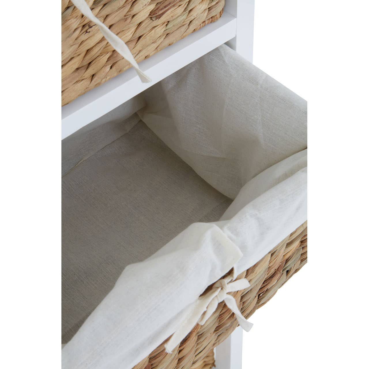 A close-up view of an open drawer from the Ashby 3 Seagrass Drawer Chest, featuring a woven seagrass basket with a cream-colored fabric liner. The drawer is positioned within a white wooden frame, showcasing the interior space of the basket